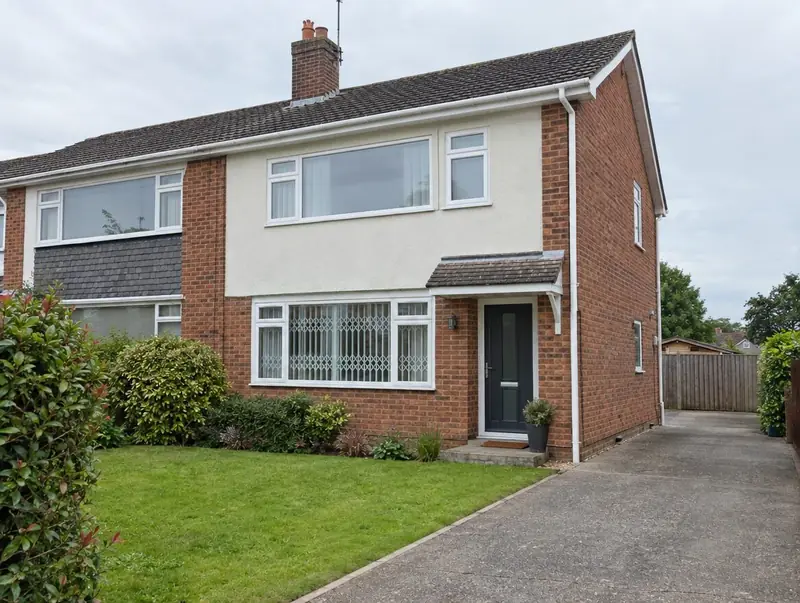 Semi-detached house with a discreet white grille behind the ground-floor window